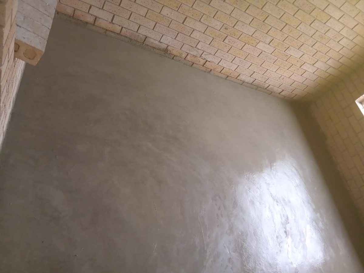 Freshly plastered floor and wall screeding in a new brick room