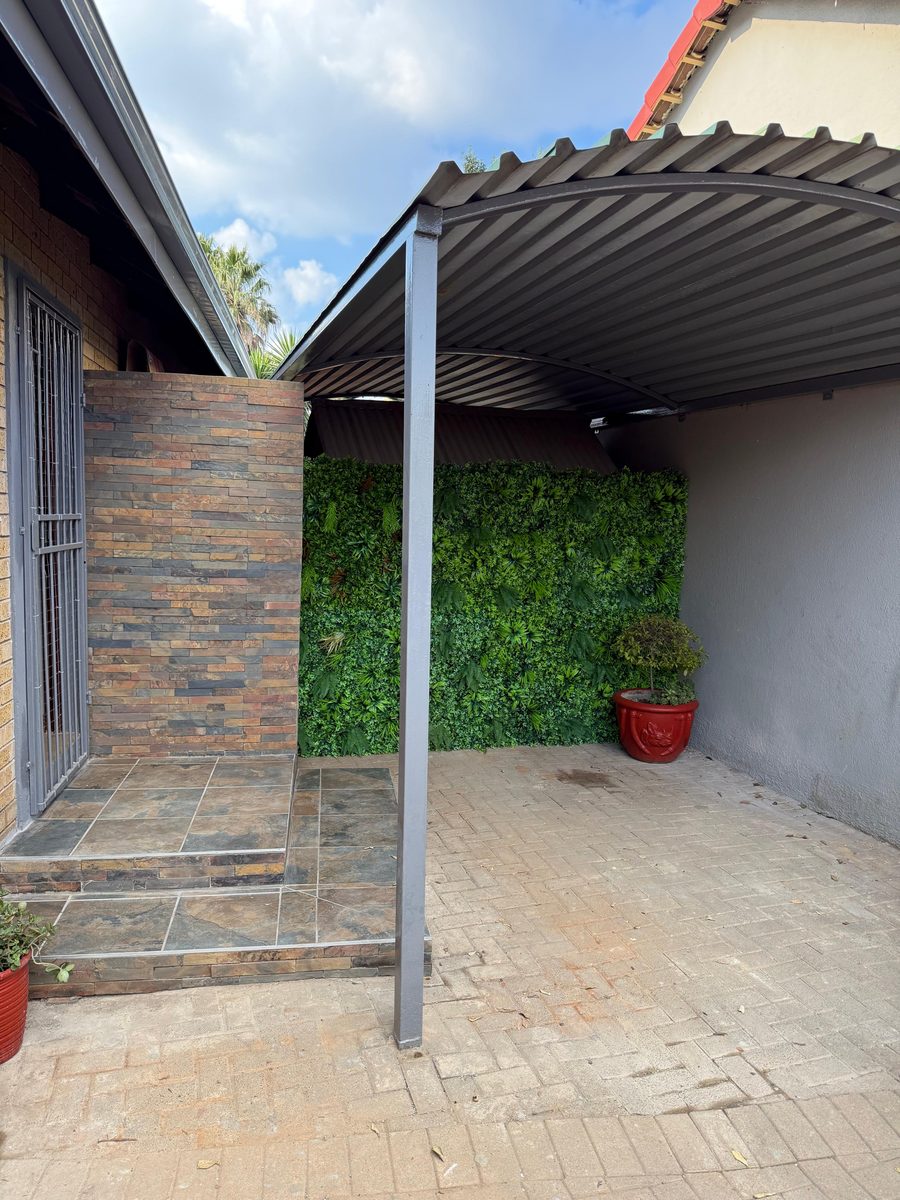 Renovated home patio with a covered carport and living green wall
