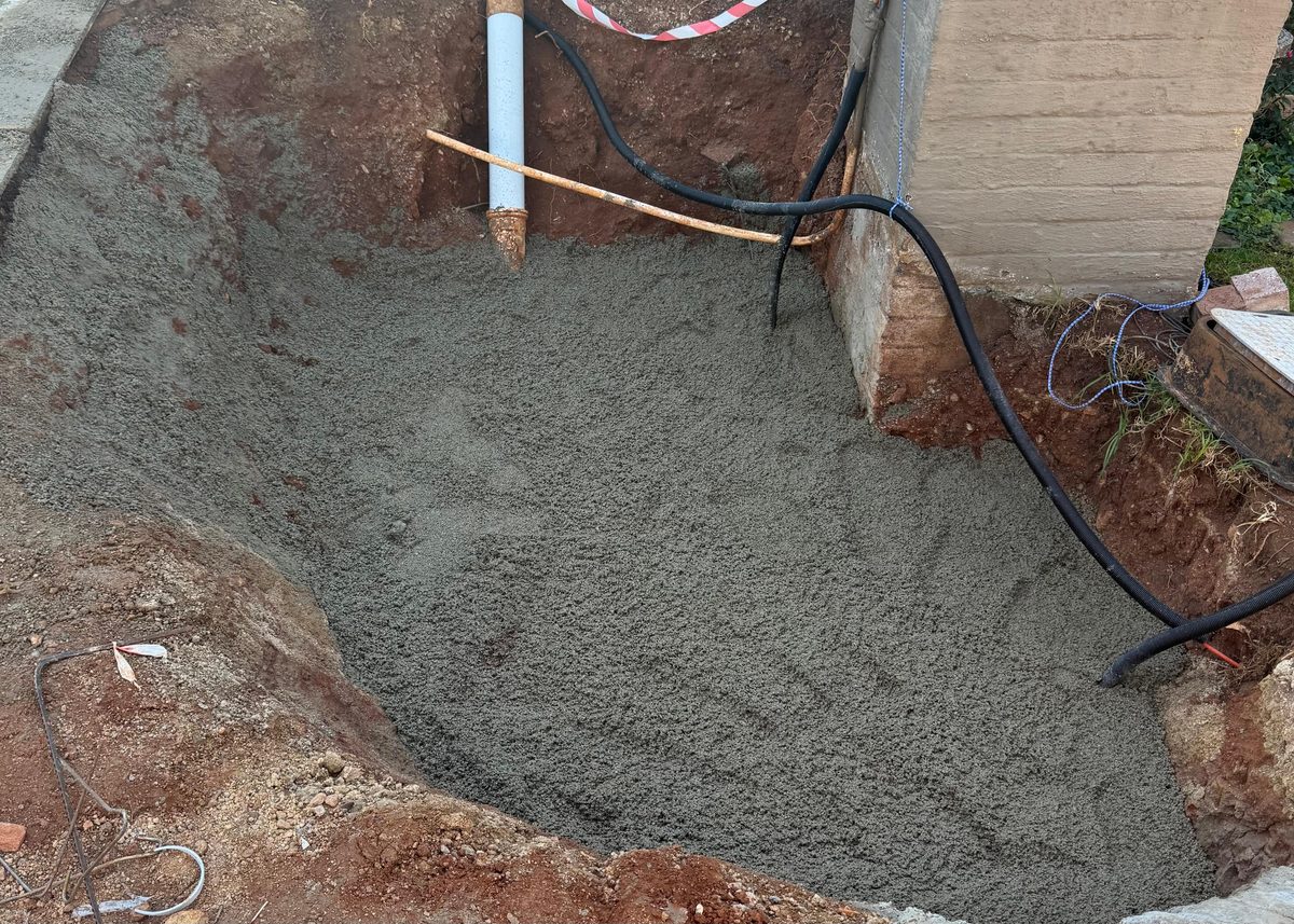 Sinkhole excavation filled and repaired with concrete at a residential property