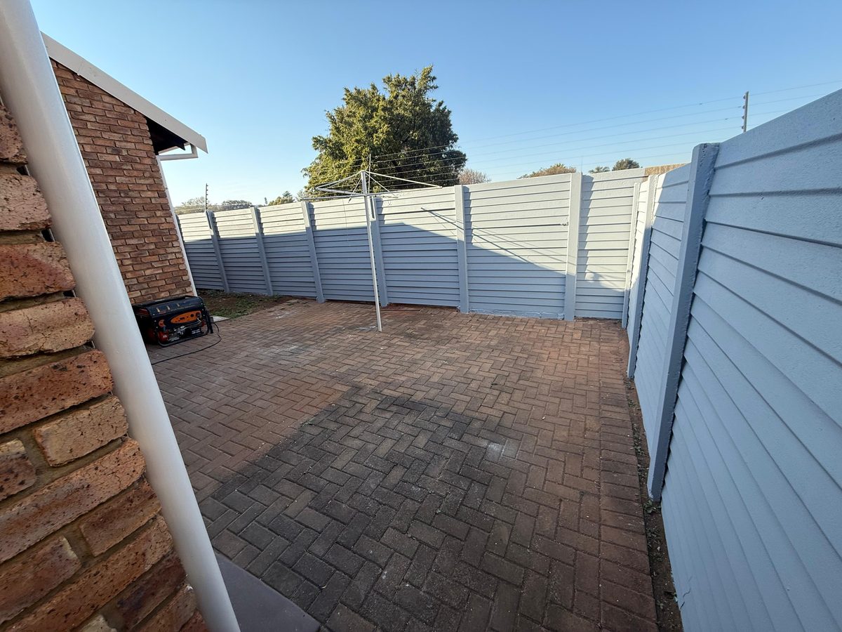 Repainted residential boundary wall and fence in slate blue-grey